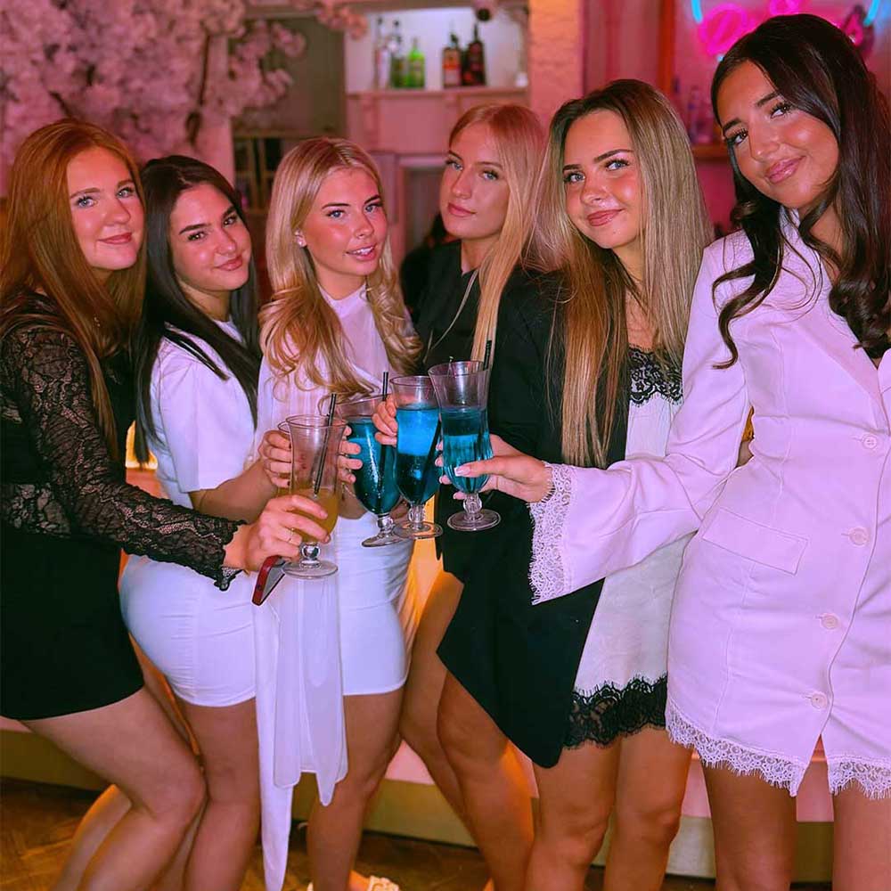 Group of women posing together with bottomless cocktails at a bottomless brunch event with Lovebrunch in Greenwich